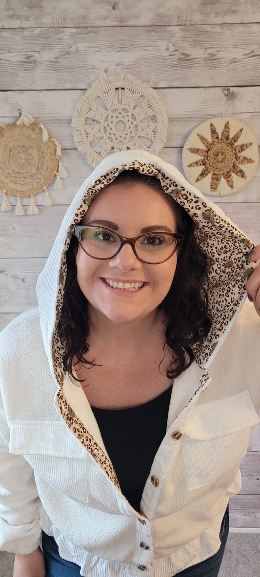 Stay cozy and stylish in the Margo Ivory Sherpa Hoodie Jacket! Crafted with practical details like a button-down front and functional hood, this peplum-style jacket will become your favorite go-to for cool days. The ivory fabric is lined with a bold leopard and floral print, adding a fun, fashionable twist. Get ready to cuddle up! Sizes small through large.