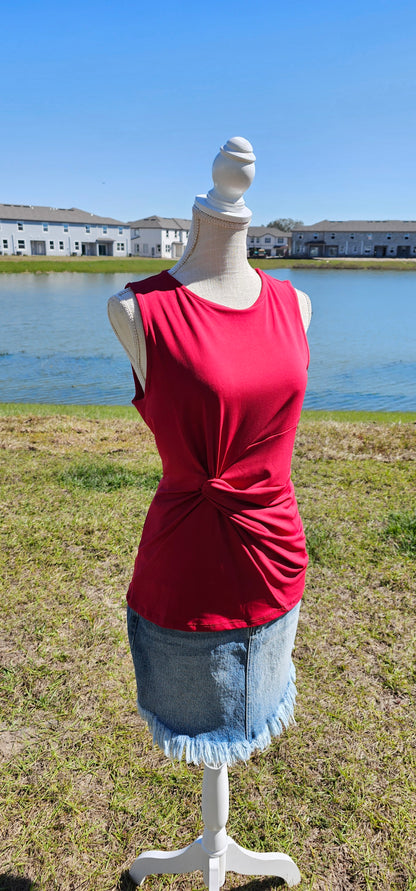 This is a perfect basic staple piece! It is a great piece for layering or great all by itself! This is a sleeveless round neck top, with a knot in front which gives it a gathered layered look, and straight line hem. The color is red. Pair with your favorite pair of denim jeans, shorts, or skirt. Sizes small through x-large.