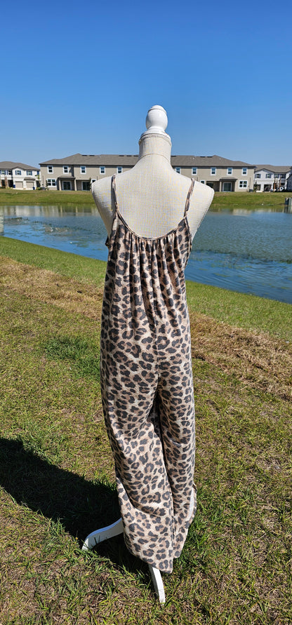 Leopard jumpsuit with side slits, adjustable straps, functional pockets. Sizes small through x-large.