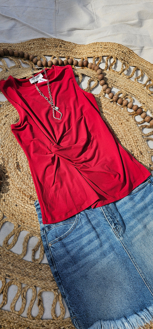 This is a perfect basic staple piece! It is a great piece for layering or great all by itself! This is a sleeveless round neck top, with a knot in front which gives it a gathered layered look, and straight line hem. The color is red. Pair with your favorite pair of denim jeans, shorts, or skirt. Sizes small through x-large.