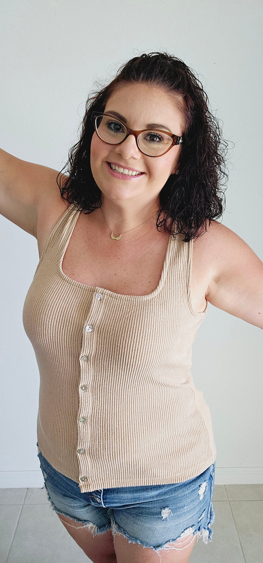 This tank top features a unique square neckline and a classic ribbed design in a washed tan color. Perfect for layering or wearing on its own, this tank is a versatile addition to your wardrobe. Sizes small through large.