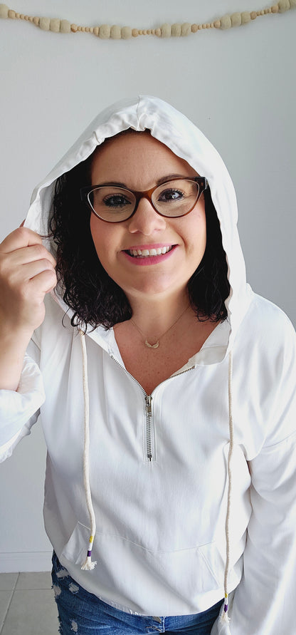 Stay cute and stylish with this hoodie top! This playful top features a drawstring with trim detail, half zip up, hood, kangaroo pocket, and elastic waistband. Perfect for lounging or running errands, this top adds a touch of fun to any outfit. Sizes small through large.