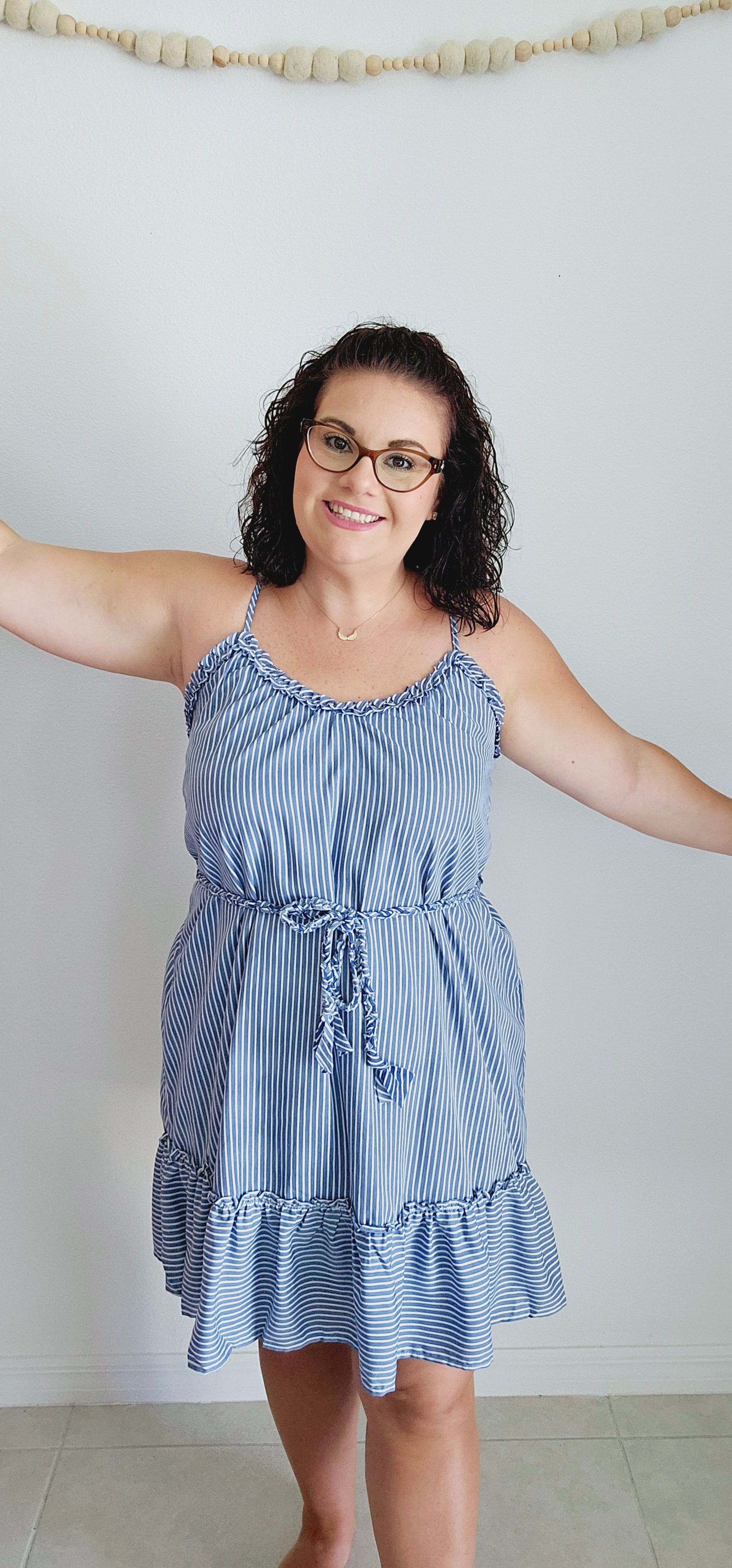 Get ready for some serious beach vibes with this gorgeous dress. This dress features a playful ruffle trim and hem, adjustable spaghetti straps for the perfect fit, and a braided belt for a touch of uniqueness. The vertical royal blue and white stripes will have you feeling like a seaside goddess. Sizes small through large.