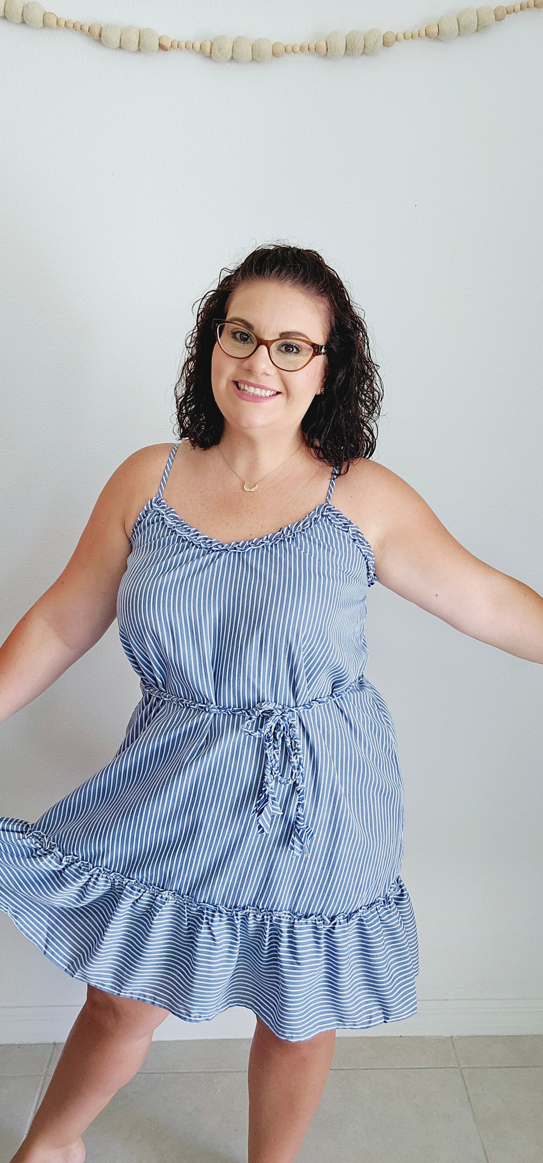 Get ready for some serious beach vibes with this gorgeous dress. This dress features a playful ruffle trim and hem, adjustable spaghetti straps for the perfect fit, and a braided belt for a touch of uniqueness. The vertical royal blue and white stripes will have you feeling like a seaside goddess. Sizes small through large.