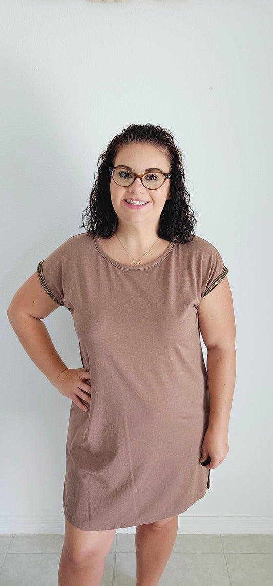 This T-shirt dress boasts an edgy washed effect and eye-catching bead trim for a unique and playful look. Perfect for any casual occasion, you'll be sure to turn heads and have fun in this mocha dress. Sizes small through large.