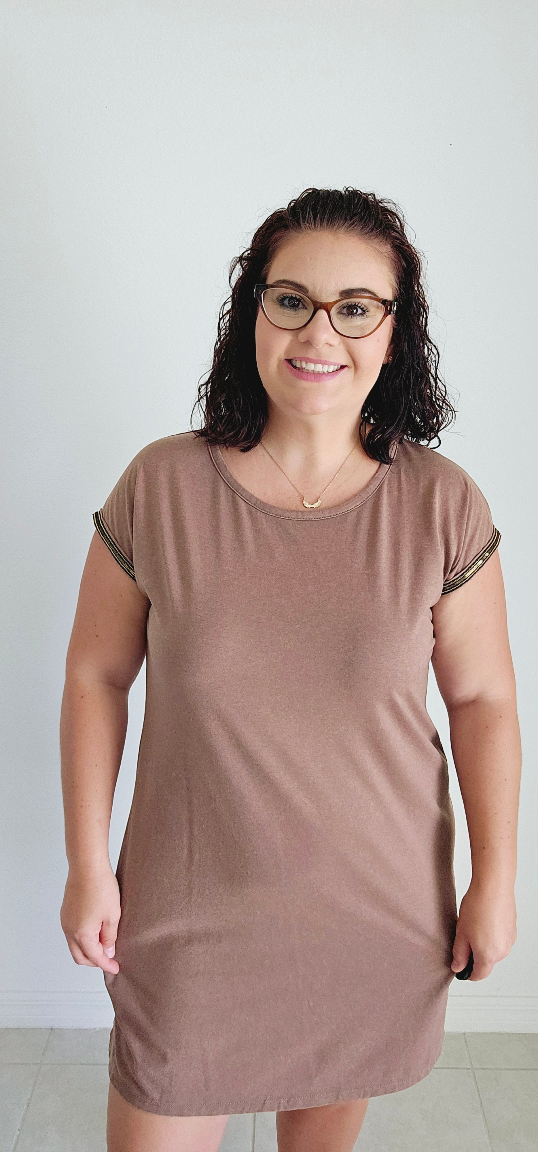 This T-shirt dress boasts an edgy washed effect and eye-catching bead trim for a unique and playful look. Perfect for any casual occasion, you'll be sure to turn heads and have fun in this mocha dress. Sizes small through large.