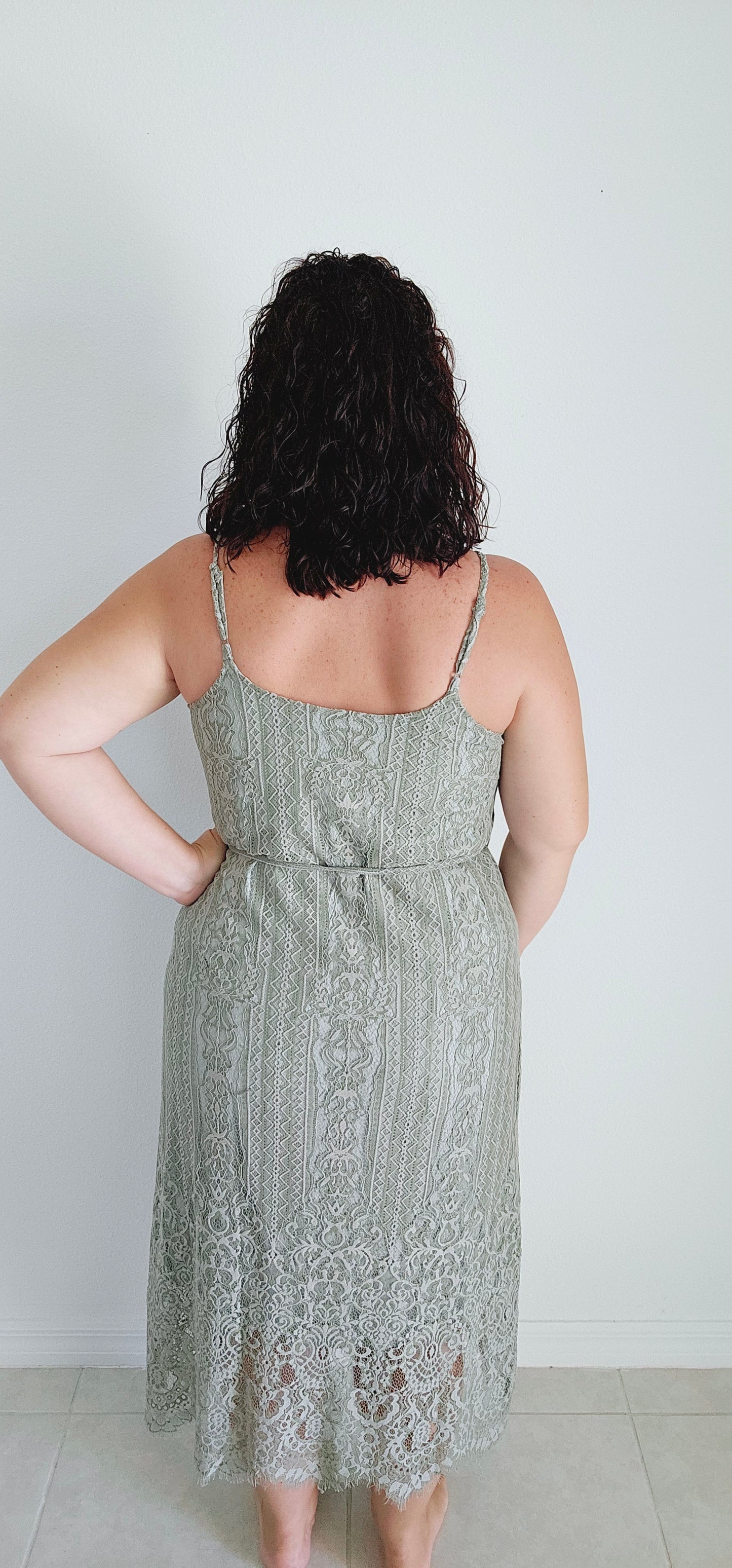 This A-line slip dress features a delicate lace overlay and a flattering waist tie, perfect for accentuating your figure. With adjustable shoulder straps and a soft rayon lining, this dress is both stylish and comfortable. Wear it to your next event for a touch of elegance with a modern twist. Sizes small through large.
