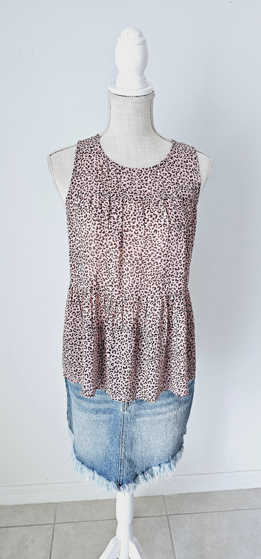 Fancy & Free is a A-line, leopard print, tiered top is sleeveless, flowy and sheer. It features a key hole back with button closure, and has a rounded neckline.&nbsp; This top is light pink with brown leopard print. It is great for vacation, an evening out, casual event, a day out on the town with your friends, or just because. Sizes small through large.