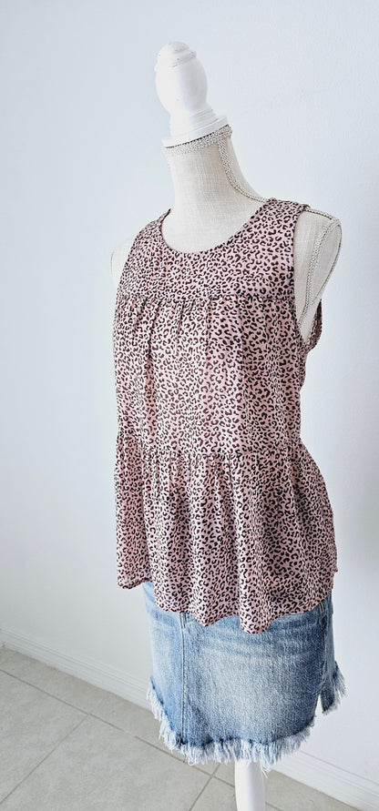 Fancy & Free is a A-line, leopard print, tiered top is sleeveless, flowy and sheer. It features a key hole back with button closure, and has a rounded neckline.&nbsp; This top is light pink with brown leopard print. It is great for vacation, an evening out, casual event, a day out on the town with your friends, or just because. Sizes small through large.