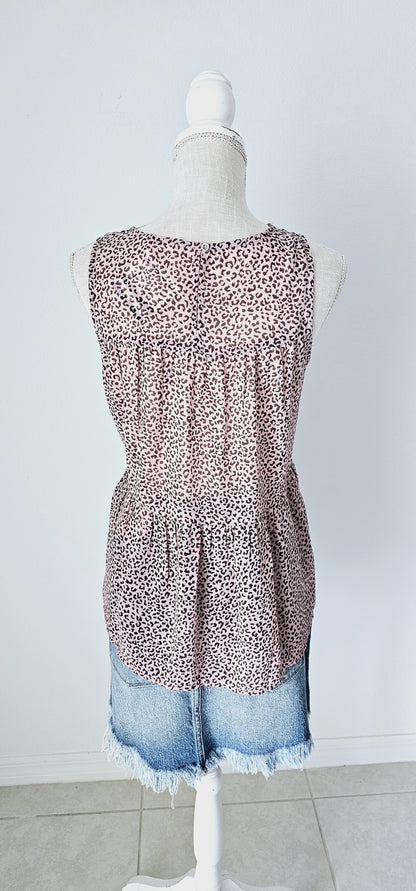 Fancy & Free is a A-line, leopard print, tiered top is sleeveless, flowy and sheer. It features a key hole back with button closure, and has a rounded neckline.&nbsp; This top is light pink with brown leopard print. It is great for vacation, an evening out, casual event, a day out on the town with your friends, or just because. Sizes small through large.