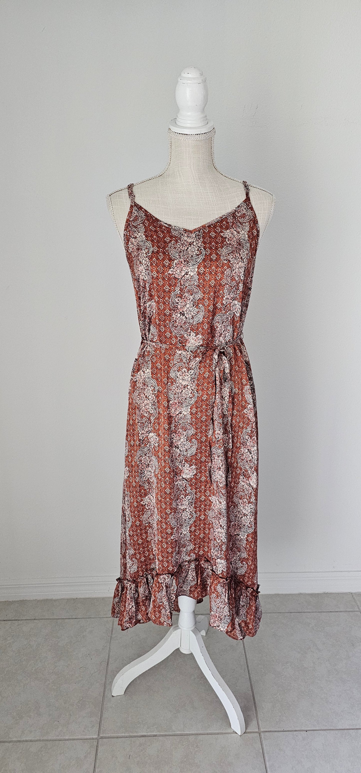 Make a statement in the "Neriah Rust Paisley Slip Midi Dress"! This stunning high-low dress features a classic paisley pattern, a flouncy ruffle hem, adjustable spaghetti straps, and a thin waist tie strap for you to cinch and flaunt. So, go ahead and show off your gorgeously rustic style! Sizes small through large.