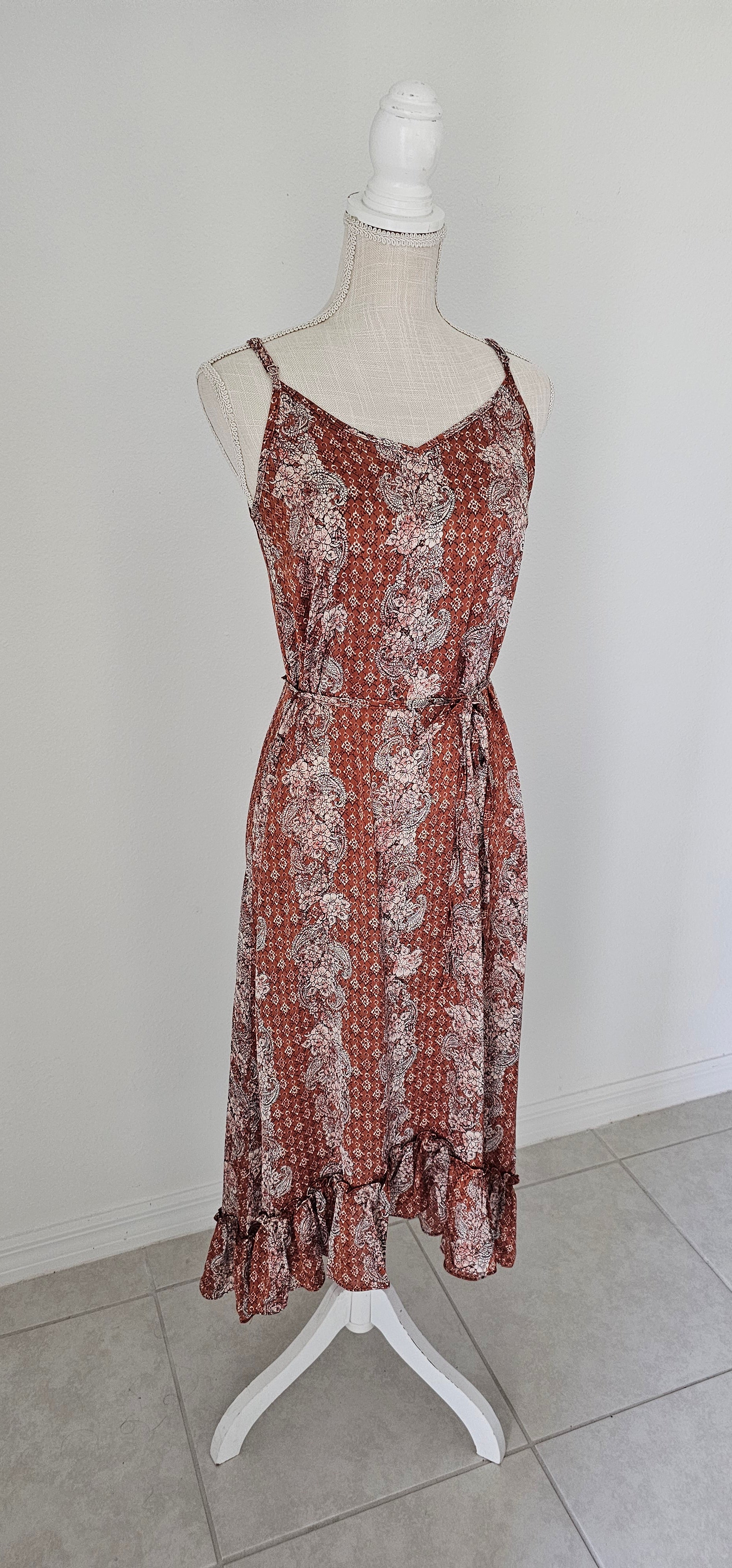 Make a statement in the "Neriah Rust Paisley Slip Midi Dress"! This stunning high-low dress features a classic paisley pattern, a flouncy ruffle hem, adjustable spaghetti straps, and a thin waist tie strap for you to cinch and flaunt. So, go ahead and show off your gorgeously rustic style! Sizes small through large.