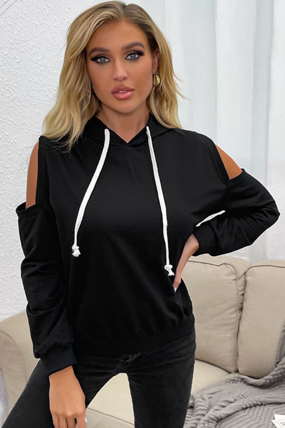 “Evening Errands” is a long sleeve top featuring colder shoulder peek-a-boo cutouts, hoodie with drawstring. Sizes medium through x-large.