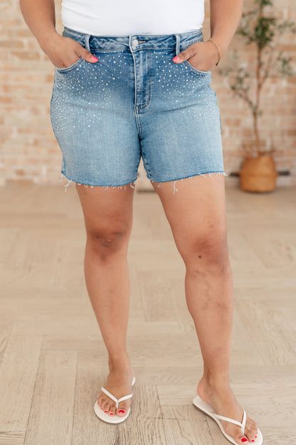 Elevate your style with Elle High Rise Rhinestone Cutoff Shorts. The high rise design flatters your figure, while the rhinestone embellishment adds a touch of sparkle. The raw cutoff hem and medium wash give a trendy, edgy vibe. Step out in confidence with these statement shorts. S-3X