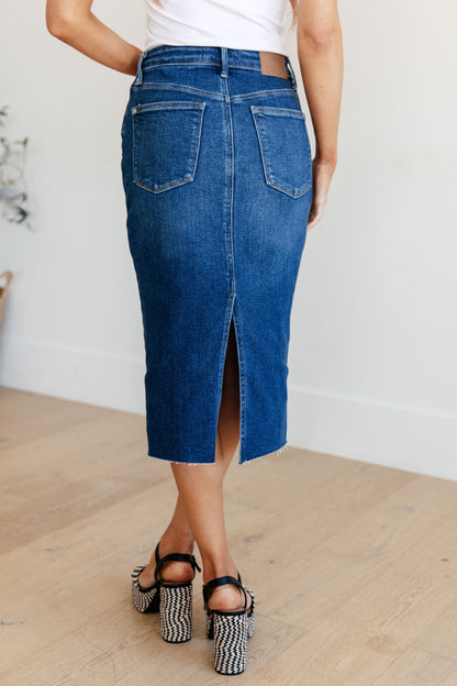 Get ready to rock your denim look with the Marcy High Rise Denim Midi Skirt from Judy Blue! With a flattering high rise fit and a versatile dark wash, this skirt is perfect for any occasion. The 4-way stretch and back vent provide a comfortable and stylish fit, while the raw hem adds a touch of edge. Say goodbye to ill-fitting skirts and hello to the perfect fit! s-3x