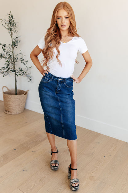 Get ready to rock your denim look with the Marcy High Rise Denim Midi Skirt from Judy Blue! With a flattering high rise fit and a versatile dark wash, this skirt is perfect for any occasion. The 4-way stretch and back vent provide a comfortable and stylish fit, while the raw hem adds a touch of edge. Say goodbye to ill-fitting skirts and hello to the perfect fit! s-3x