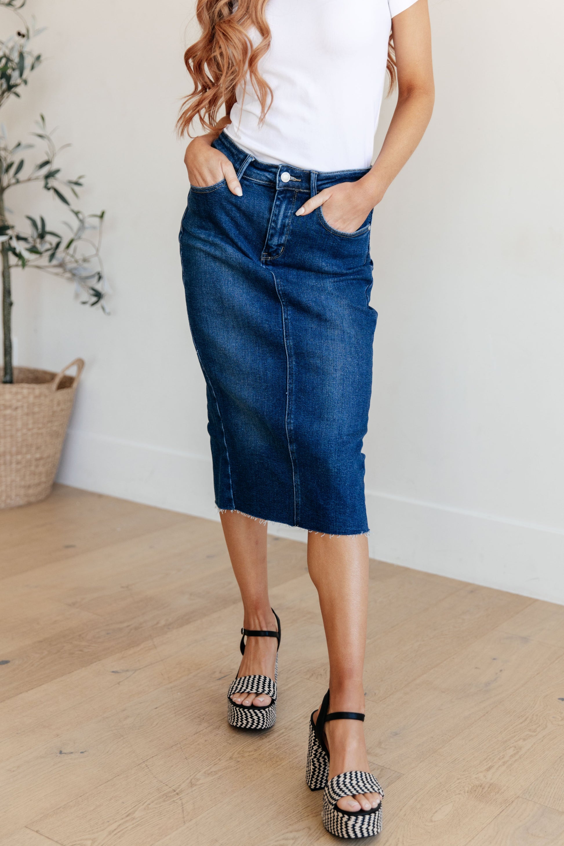 Get ready to rock your denim look with the Marcy High Rise Denim Midi Skirt from Judy Blue! With a flattering high rise fit and a versatile dark wash, this skirt is perfect for any occasion. The 4-way stretch and back vent provide a comfortable and stylish fit, while the raw hem adds a touch of edge. Say goodbye to ill-fitting skirts and hello to the perfect fit! s-3x