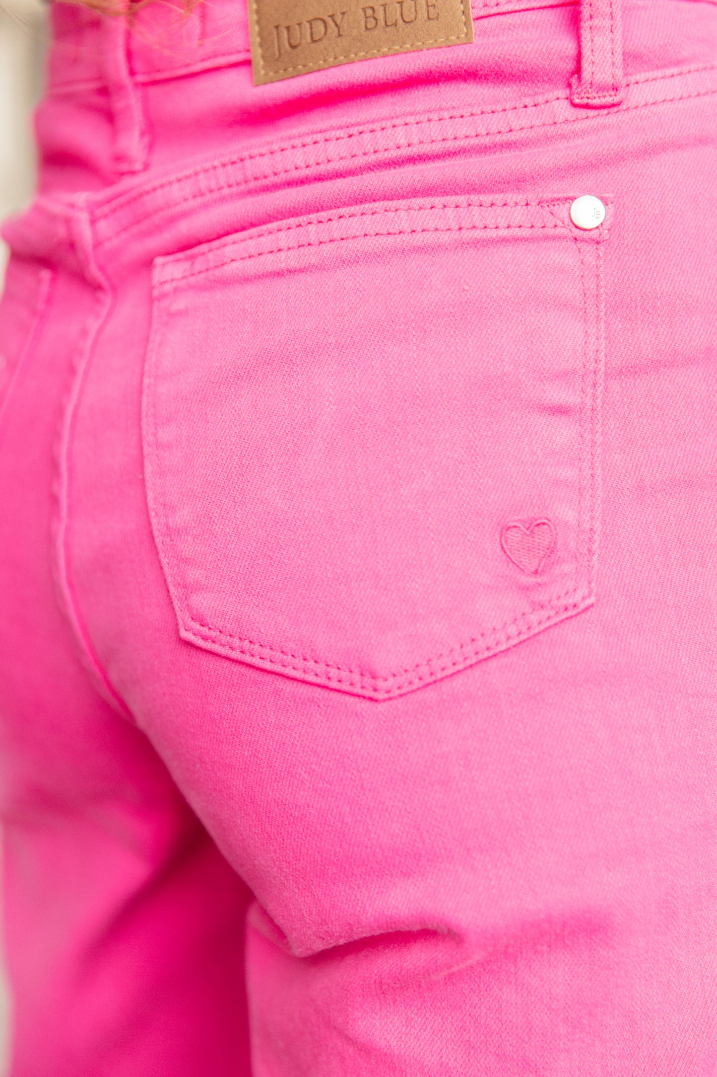  The bright pink garment dye adds a fun pop of color, and the adorable pink heart embroidered on the back pocket adds a touch of charm. Finished with a raw hem for an effortlessly cool look. Elevate your denim game with these must-have jeans.  Judy Blue 0 - 24W