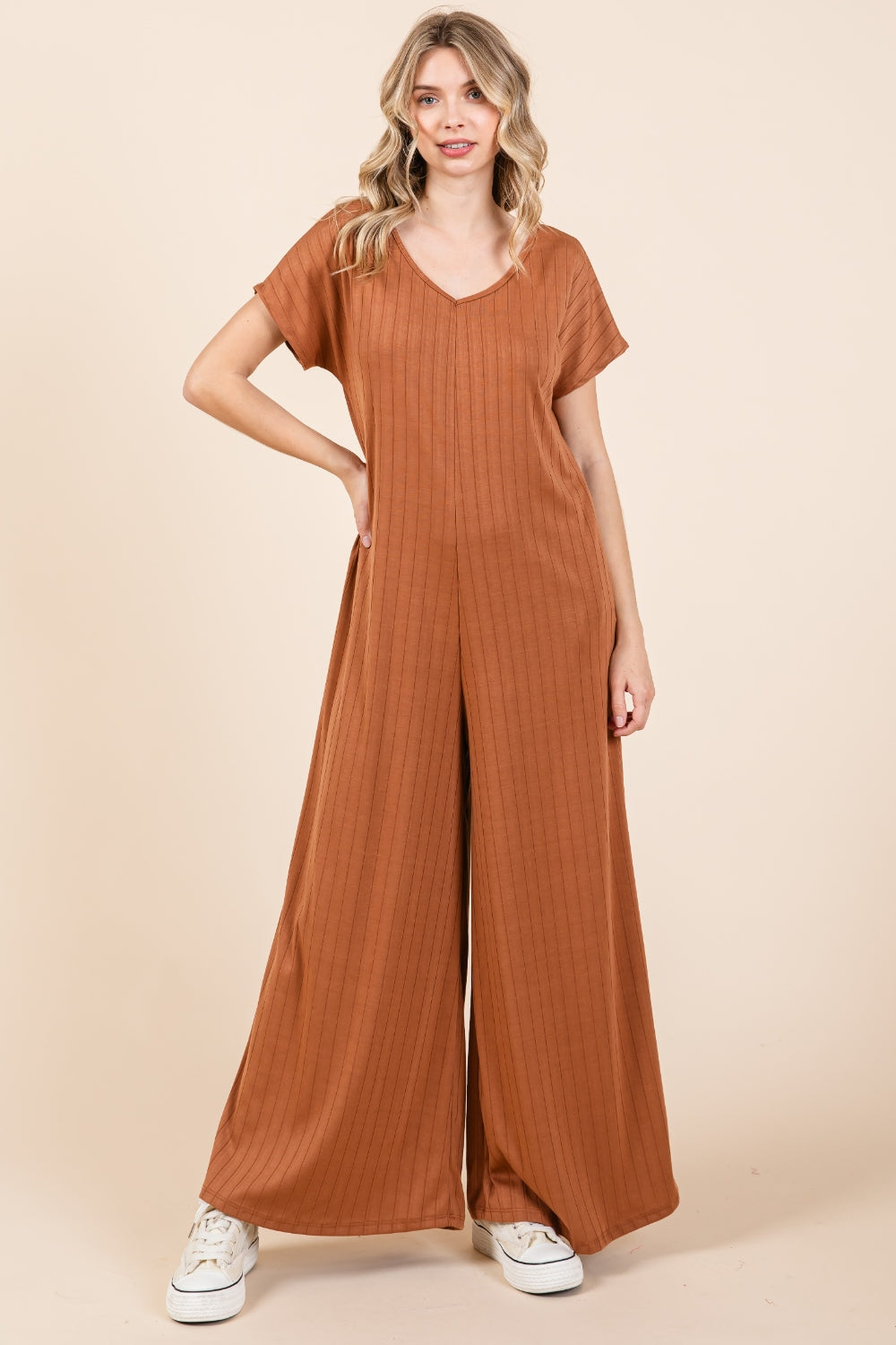 The Ribbed Short Sleeve Wide Leg Jumpsuit is a trendy and versatile fashion piece that offers both style and comfort. With a ribbed texture and wide-leg silhouette, this jumpsuit combines a chic look with a relaxed fit. The short sleeves add a casual touch, making it suitable for various occasions.  S-XL
