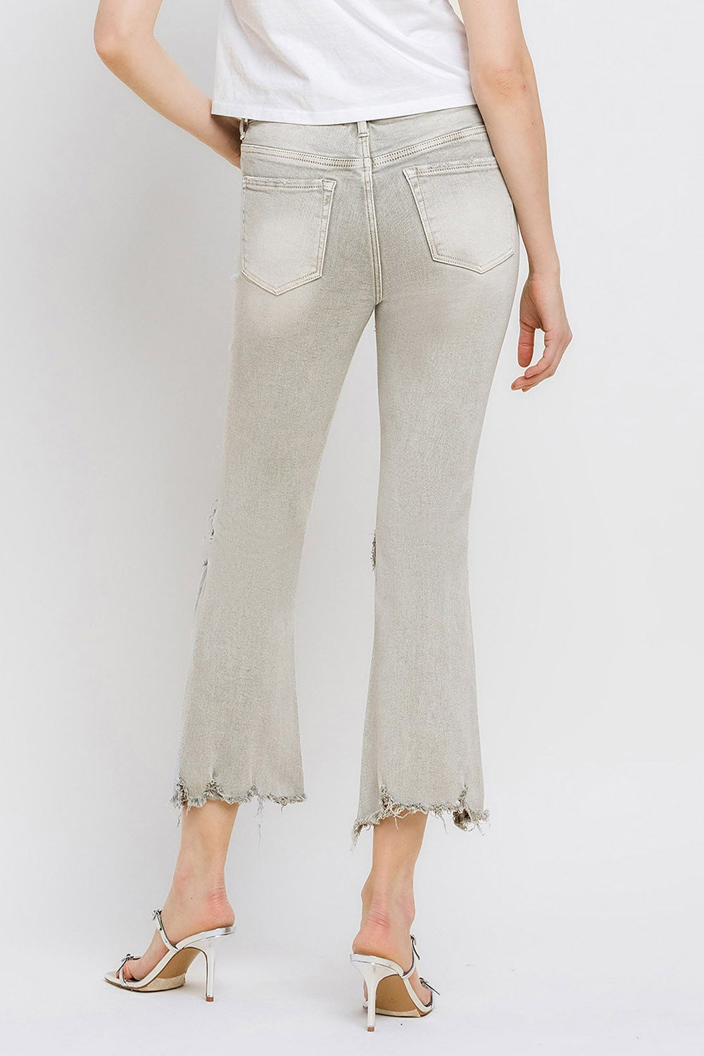 These distressed raw hem cropped flare jeans offer a perfect blend of edgy and retro style. The distressed detailing adds a touch of urban flair to the flared silhouette. The raw hem finishes off the look with a trendy, unfinished edge. Pair these jeans with a tucked-in graphic tee and platform sandals for a vintage-inspired outfit. 