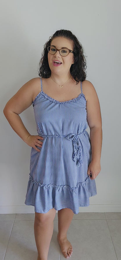 Get ready for some serious beach vibes with this gorgeous dress. This dress features a playful ruffle trim and hem, adjustable spaghetti straps for the perfect fit, and a braided belt for a touch of uniqueness. The vertical royal blue and white stripes will have you feeling like a seaside goddess. Sizes small through large.