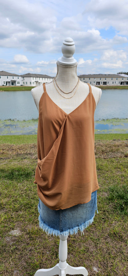 “Frappuccino” is a woven double layer chiffon top, featuring buttons up the side, surplice neckline, and adjustable spaghetti straps. This top is perfect for layering or great all by itself. Sizes small through x-large.