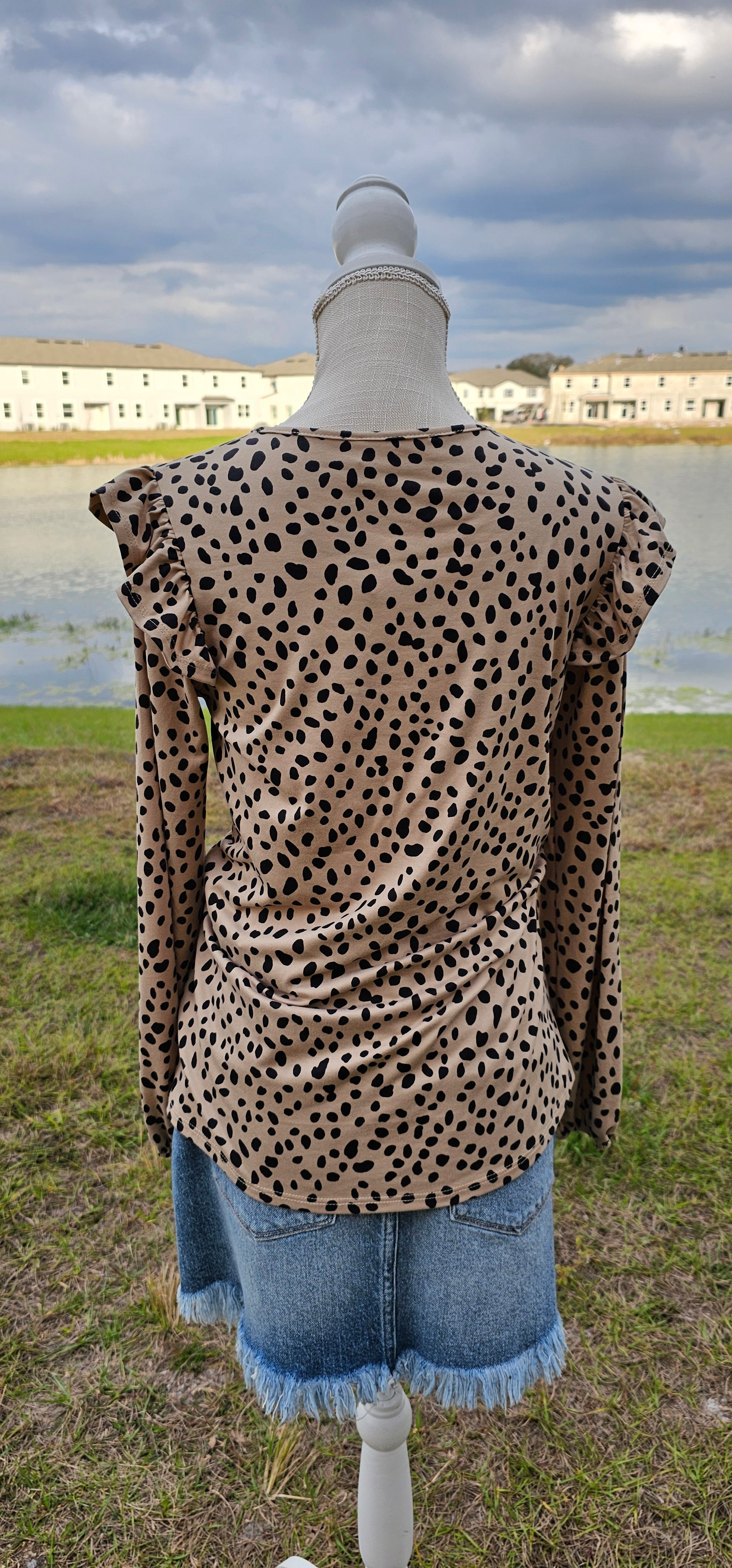 Long sleeve top with a pleaded neckline, ruffles on chest and shoulders, elastic sleeves. Sizes small through x-large.