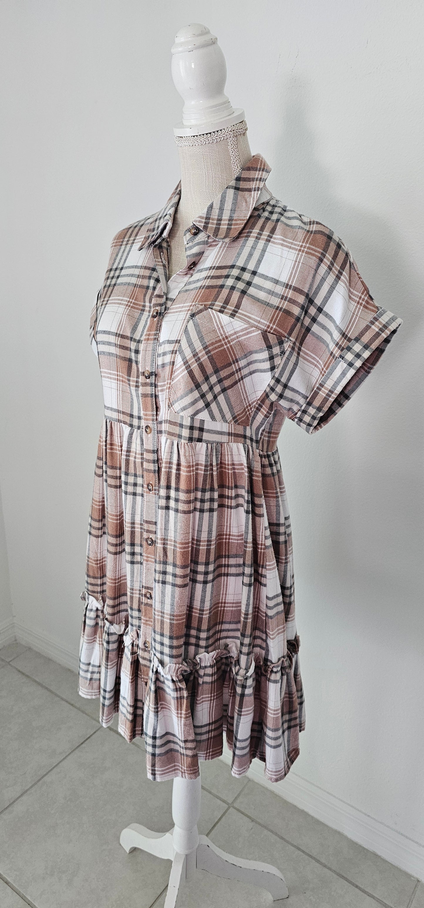 Rock your modern-meets-rustic side in this&nbsp;plaid&nbsp;mini dress! Featuring a collared neckline with button down closure, cinched waist, and a ruffle hem, you'll look fly af (as fashionable) no matter the occasion. With pocket detail, this pleated plaid piece will have you looking cute and stylish all day - yesssss girl! Sizes small through large.