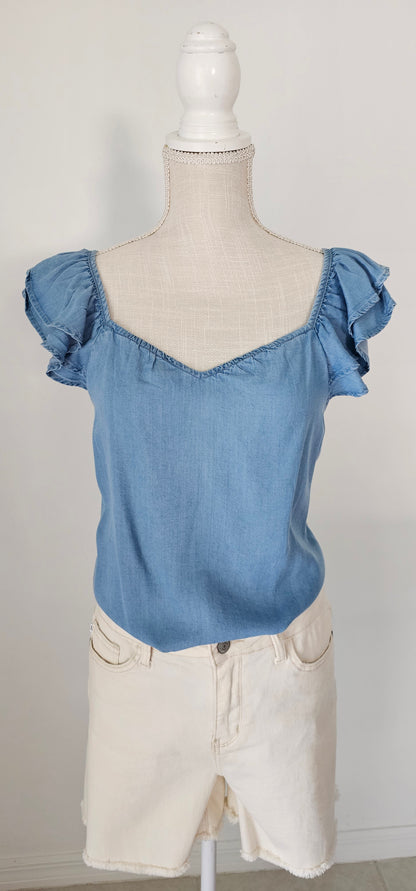 Look sharp and stylish this summer in our "Ashley Chambray Denim" top! Its flattering sweetheart neckline and sassy ruffle sleeves give you a unique, standout look. Plus, the square back neckline with elastic adds comfort! So why wait? Get out there and show off your denim 'look' with attitude. Sizes small through large.