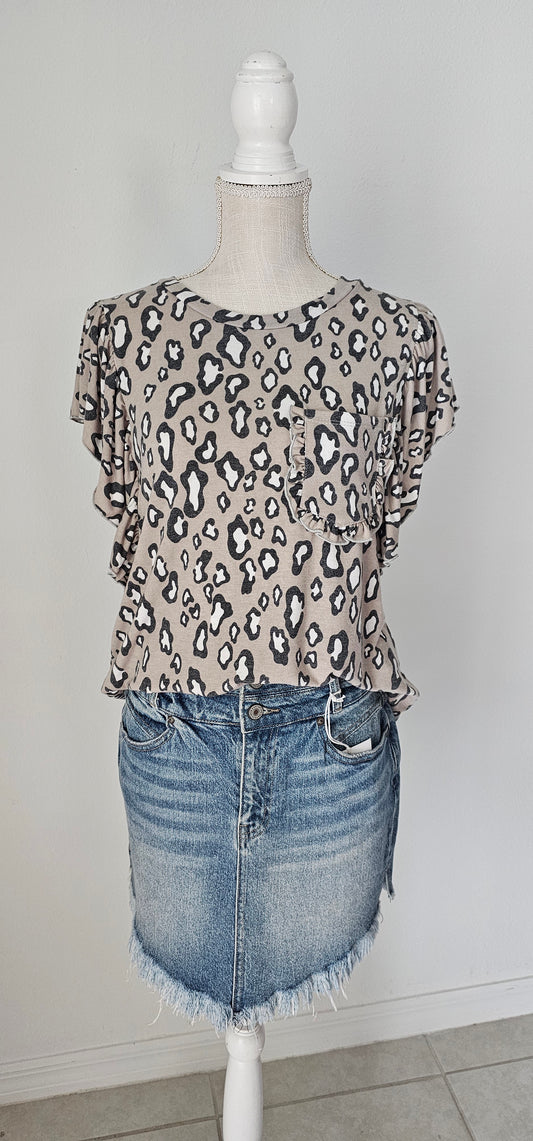 “Fearless” top features a rounded neckline, ruffled short sleeves, ruffled chest pocket, with taupe, white, and gray animal print. This top is great for vacation, those hot summer days, or a shopping day with your friends. Sizes small through large.