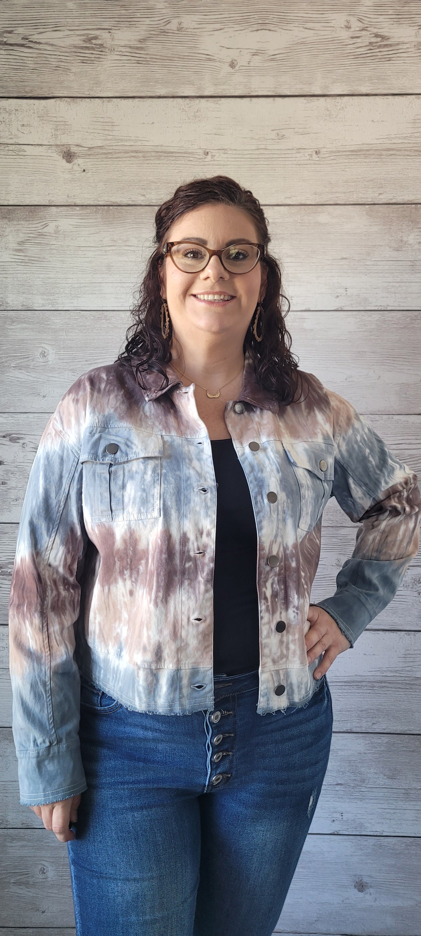 Make a statement with this adorable blue & brown tie dye trucker jacket! Enjoy the unique style of this timeless piece featuring metal button closure, bust flap pockets, and distressed hem and cuff edges. Wearing this piece is sure to cause a stir; try it and let the compliments roll in! Sizes small through large.
