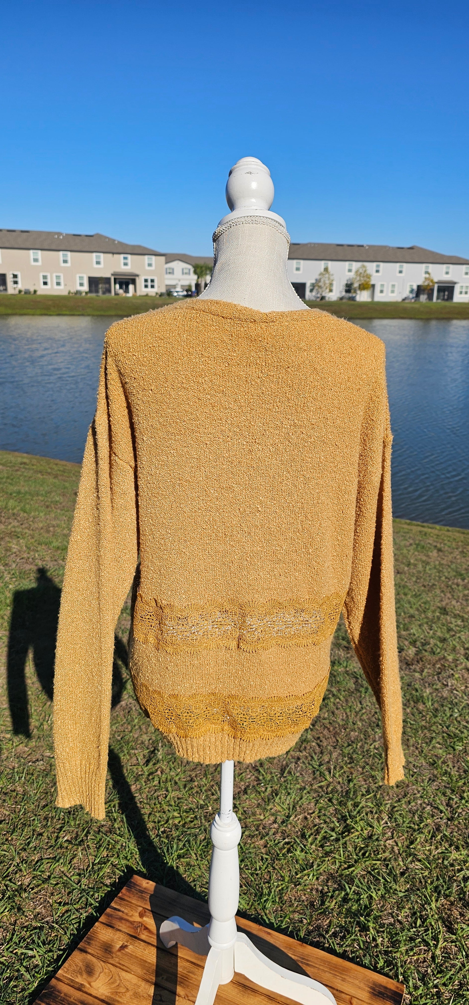 Lightweight mustard cardigan features a button down front, crotchet lace trim detailing, and a classic v-neck. Sizes small-large.