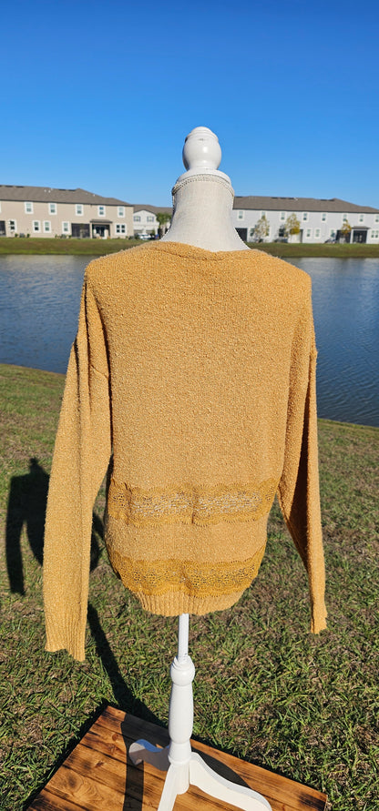 Lightweight mustard cardigan features a button down front, crotchet lace trim detailing, and a classic v-neck. Sizes small-large.
