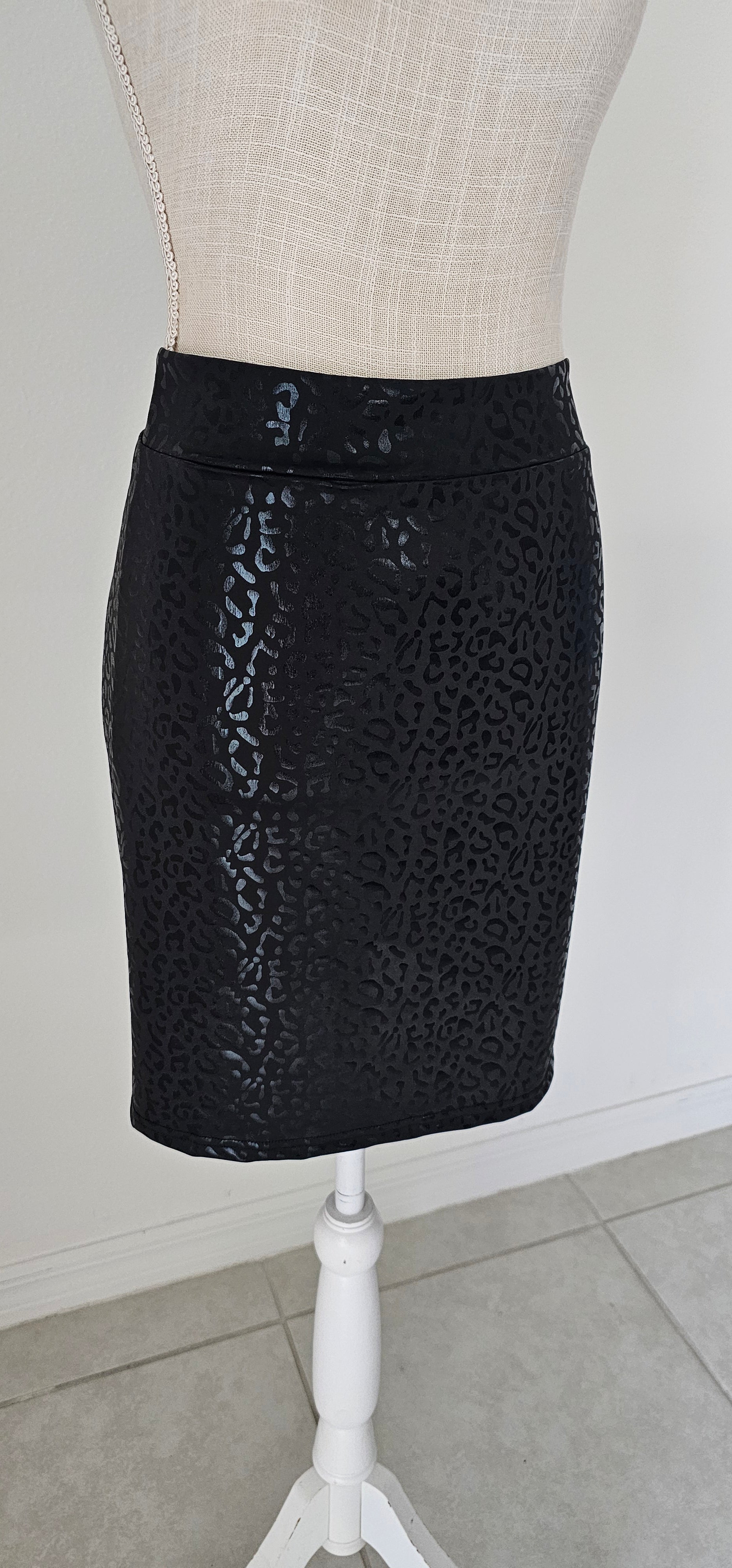 Imagine yourself in this cute little black skirt. This is a fitted mini skirt that is super edgy and chic. You'll be sure to turn heads in this skirt. It features a glossy animal print that is black, and a stretchy waist band. Go ahead and strut your stuff girl! Sizes small through x-large.