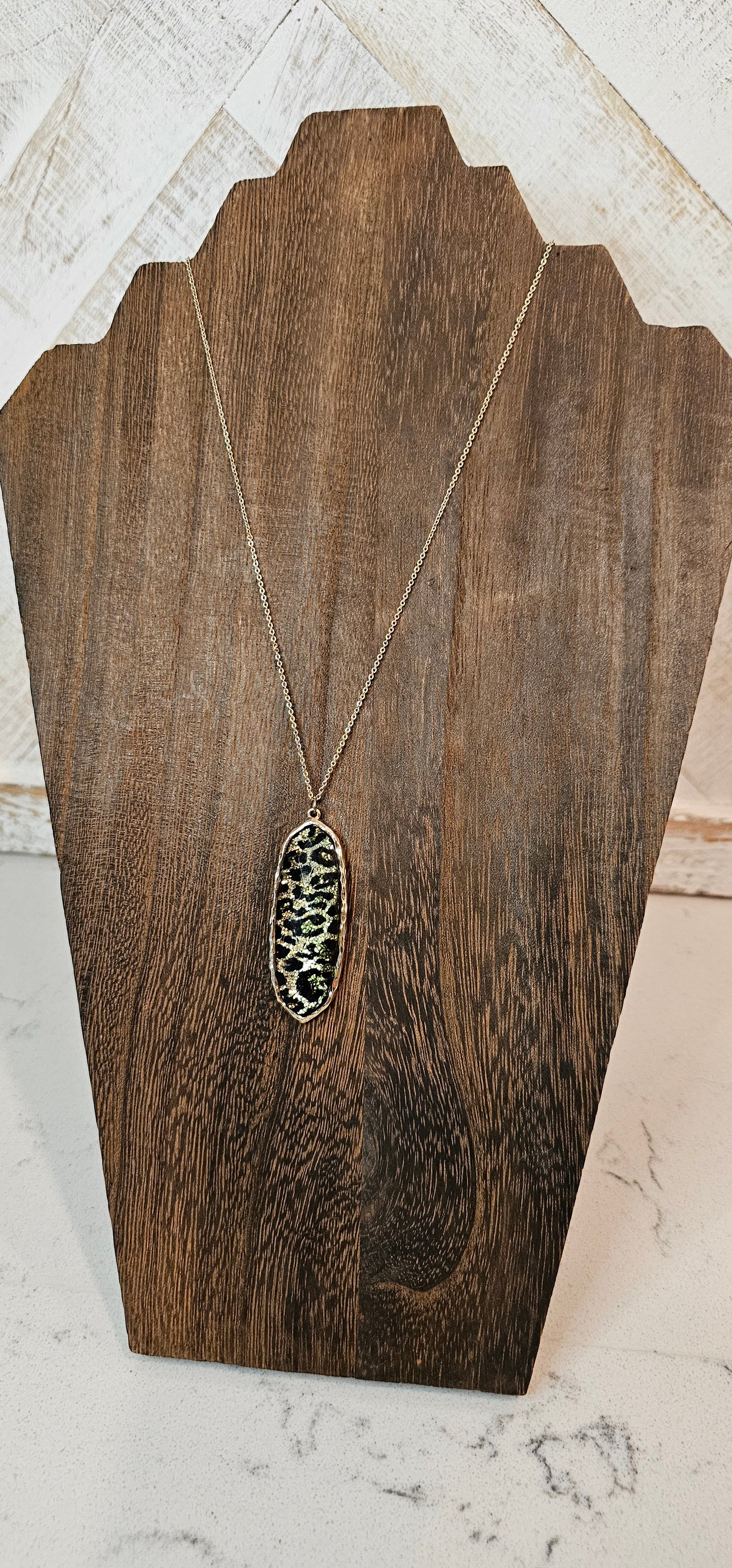 Sparkling gold color necklace with black and brown leopard print pendant. Whether you want to be on the wild side or classy this necklace will add a fun touch to your outfit. Length of chain is adjustable to 28 inches.