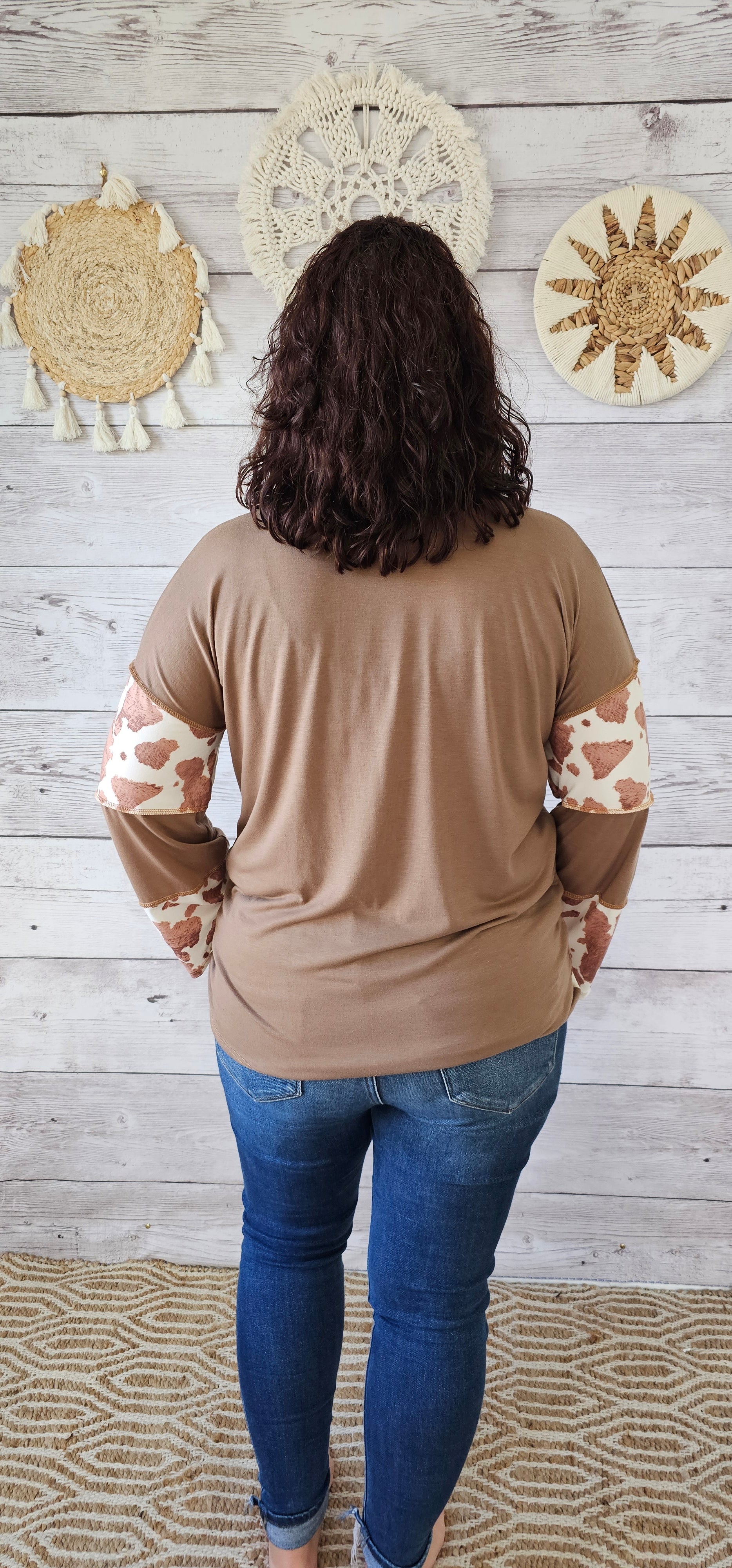 This is a long sleeve, v-neck top with an exposed seam. Cow print and mocha layers. Sizes small through x-large.