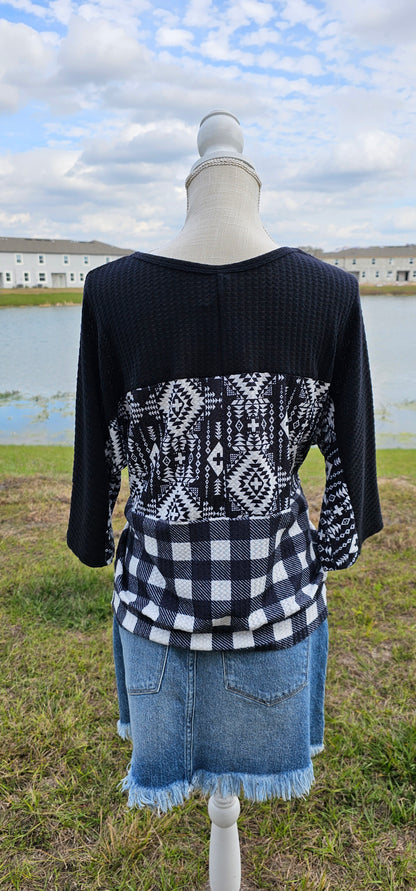Imagine yourself in this super cute Buffalo Babe top. This is a waffle top that features a solid black block, an Aztec block print, and a buffalo checked block on the front and back.  Buffalo Babe features a 3/4  sleeve which is solid black with loose fitting hem line. Go for comfort! Sizes small through x-large.