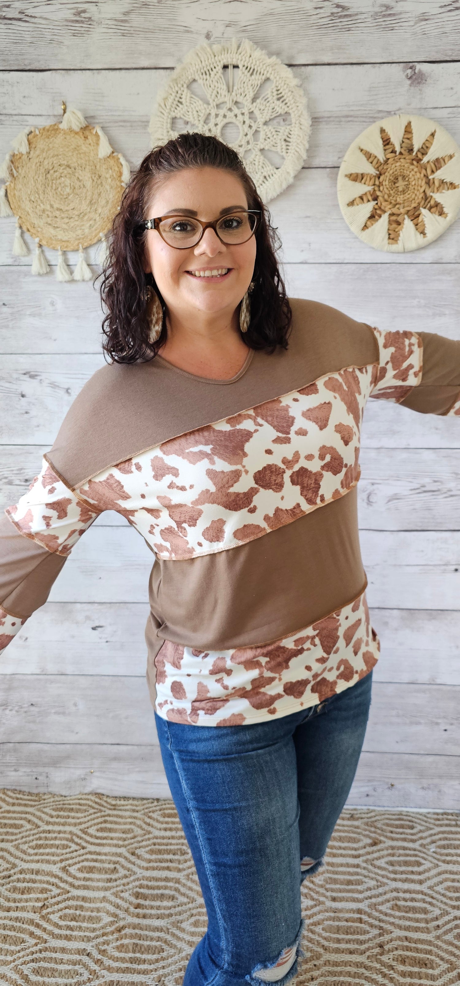 This is a long sleeve, v-neck top with an exposed seam. Cow print and mocha layers. Sizes small through x-large.