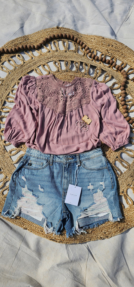 These denim distressed shorts are a light wash, high rise, frayed hem with hues of pink and blue. They are cute, edgy and scream summer vibes! Sizes small through x-large.