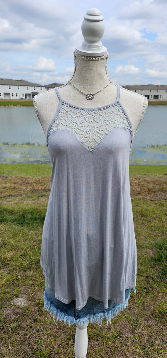 This tank is a must have! It is simple and basic. It is easy for layering or great all by itself! The tank is a relaxed fit, featuring a crocheted floral rounded neckline, curved hemline, and fixed non-adjustable straps. Color is light grey. Pair with your favorite denim jeans, tucking the corner of the tank into your belt loop or dress it up with an edgy skirt. Don’t be afraid to get creative!