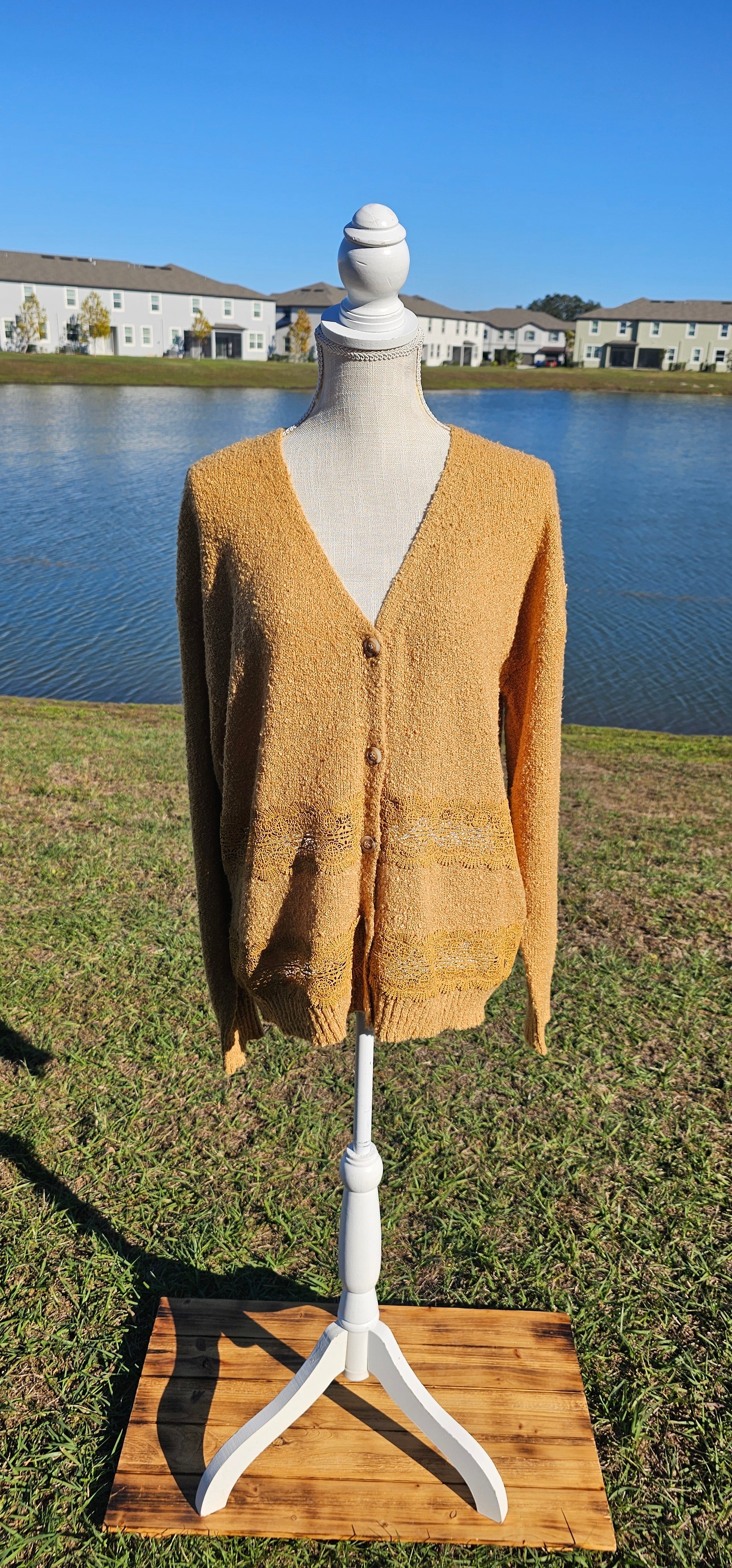 Lightweight mustard cardigan features a button down front, crotchet lace trim detailing, and a classic v-neck. Sizes small-large.