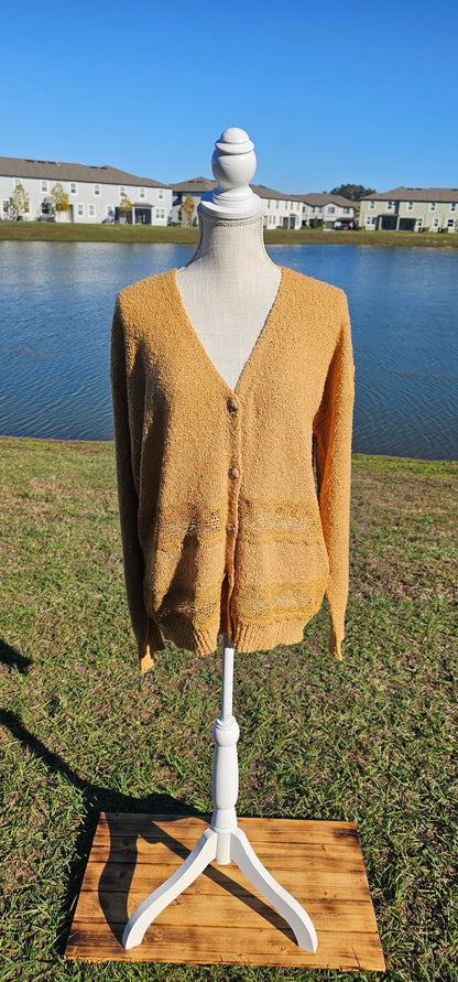 Lightweight mustard cardigan features a button down front, crotchet lace trim detailing, and a classic v-neck. Sizes small-large.