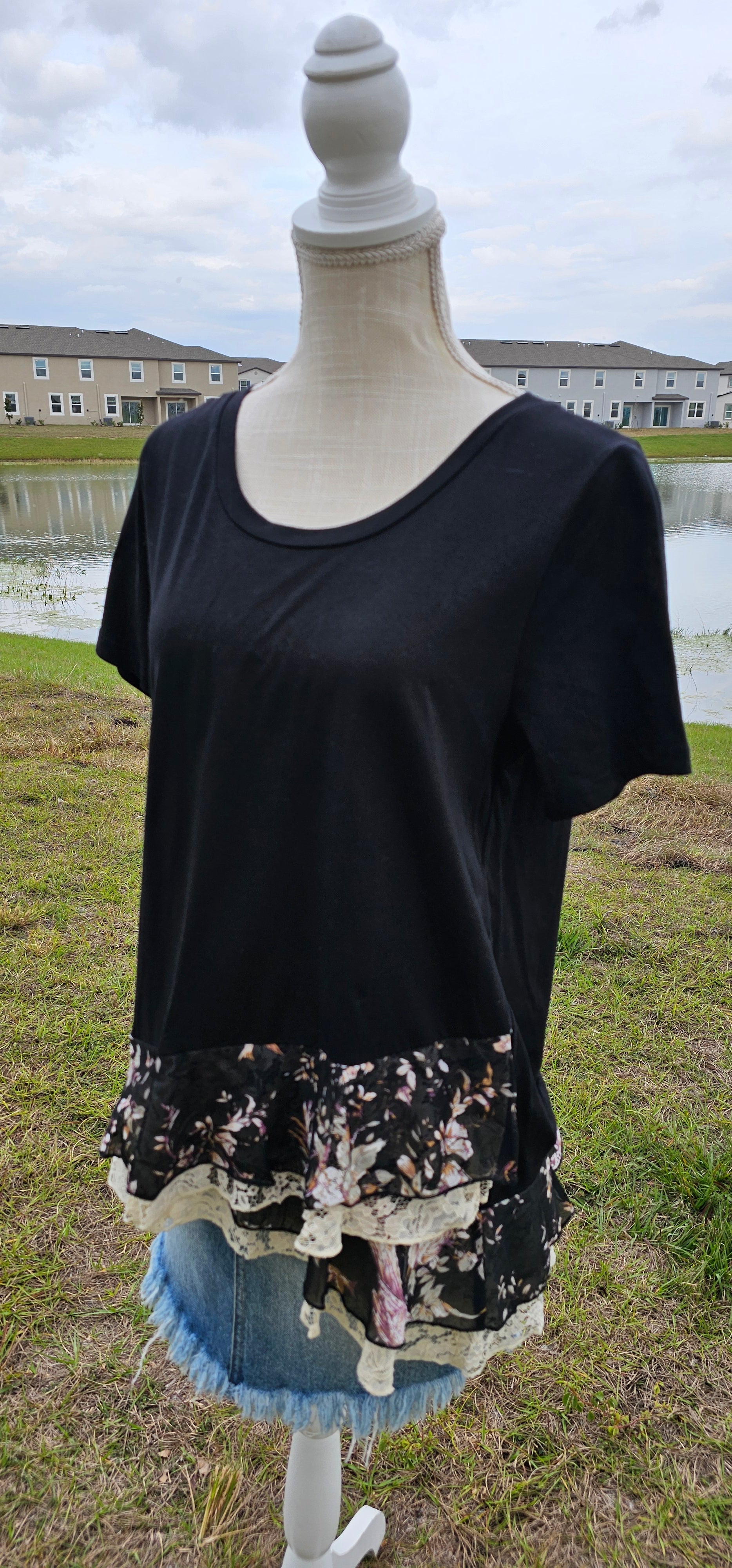 This is a comfy and casual black top, which features short sleeves, rounded neckline, layering lace and layering flowery print bottom. This is a great staple piece to your wardrobe. Sizes small through large.