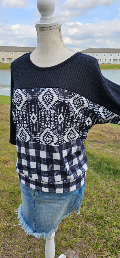 Imagine yourself in this super cute Buffalo Babe top. This is a waffle top that features a solid black block, an Aztec block print, and a buffalo checked block on the front and back.  Buffalo Babe features a 3/4  sleeve which is solid black with loose fitting hem line. Go for comfort! Sizes small through x-large.