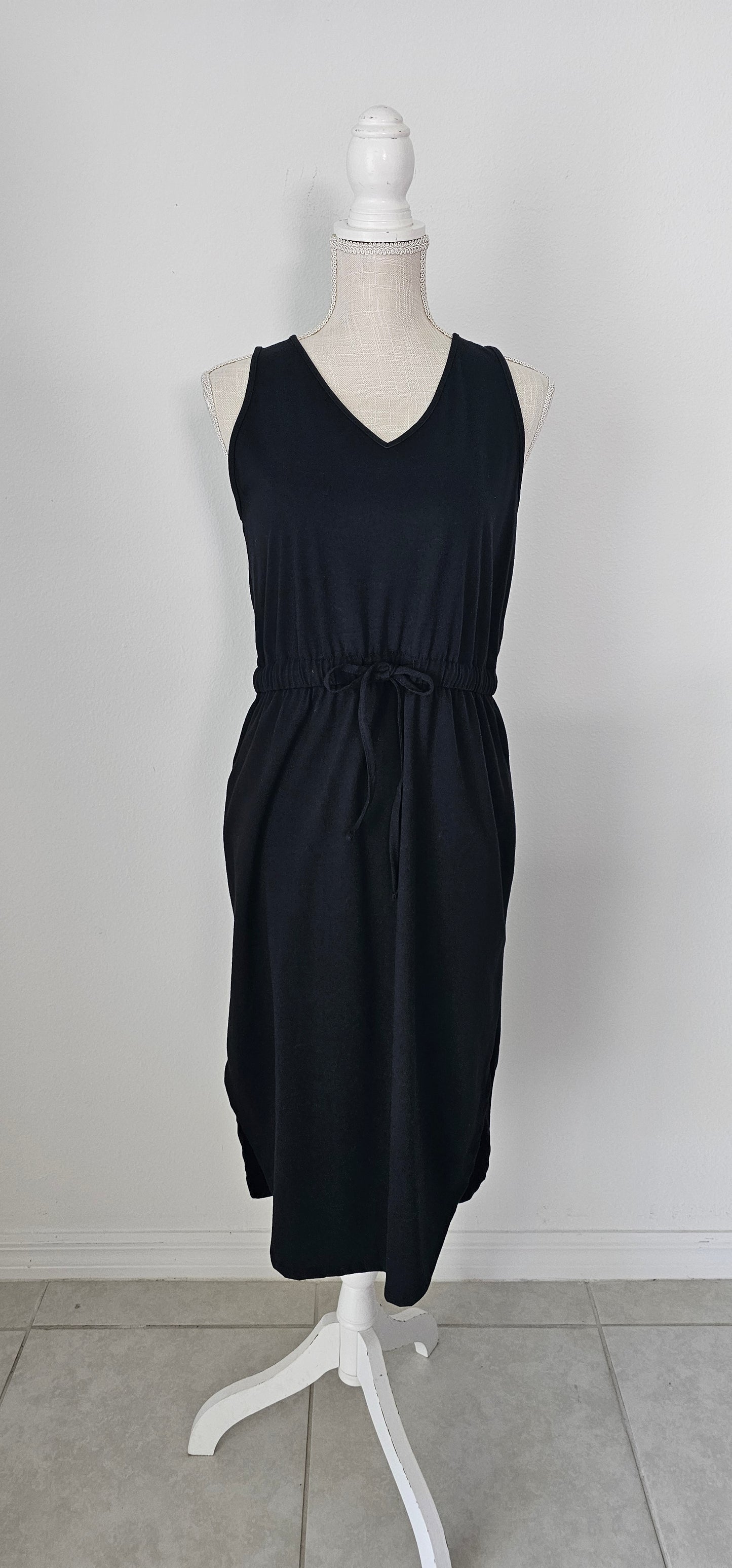 Poly cotton drawstring elastic waist curved hem dress with pockets. Sizes small through x-large.