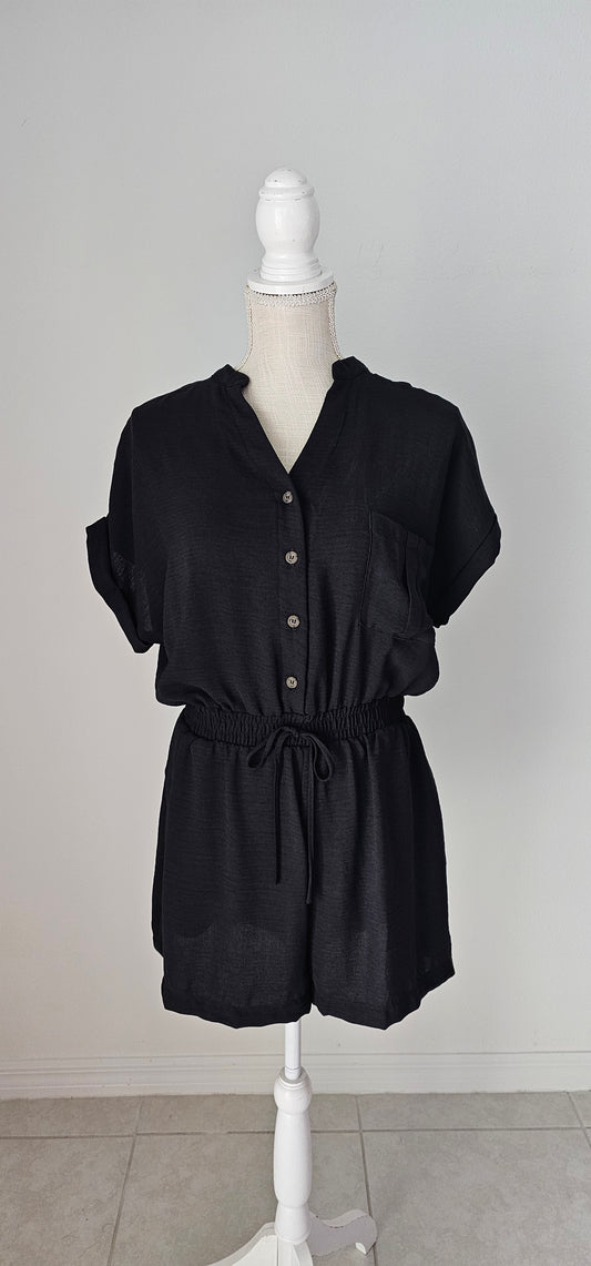 Step out in style in this black button down romper! Its lightweight fabric and classic V-neckline make it perfect for any occasion. And with its folded sleeves, high waist, elastic band, waist tie, and chest pocket, it's both chic and functional. It has two functional side pockets. A day or night look in one! Sizes small through large.