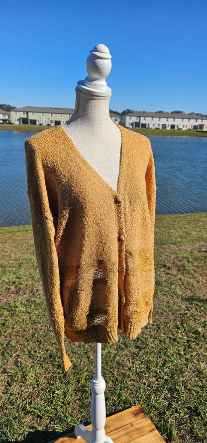 Lightweight mustard cardigan features a button down front, crotchet lace trim detailing, and a classic v-neck. Sizes small-large.