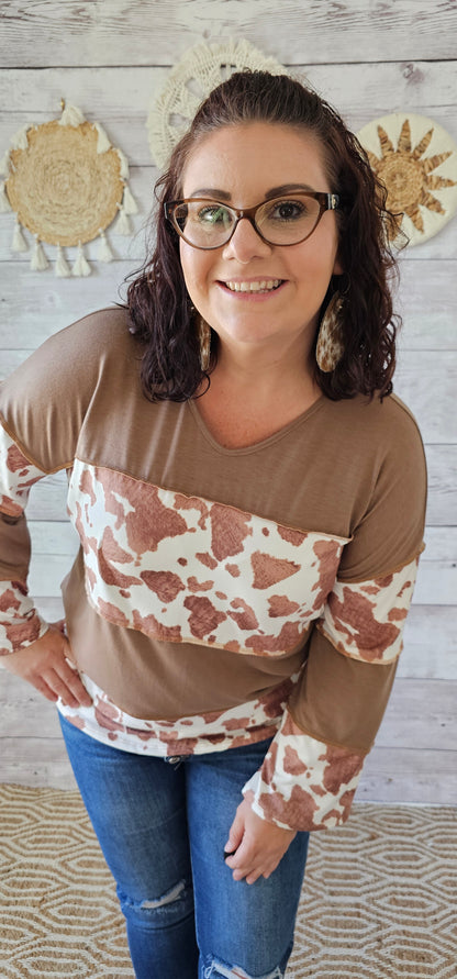 This is a long sleeve, v-neck top with an exposed seam. Cow print and mocha layers. Sizes small through x-large.
