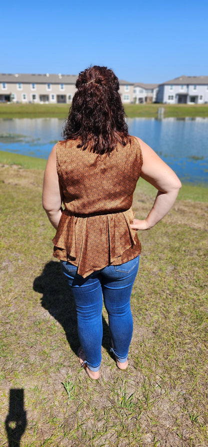 Show off your wild west style with this fashionably rustic "Merida" top! Featuring a beautiful silky satin fabric, an asymmetrical ruffle bottom, an elastic waist, and a keyhole back, you'll be riding off into the sunset in no time! Yee-haw! Sizes small through large.