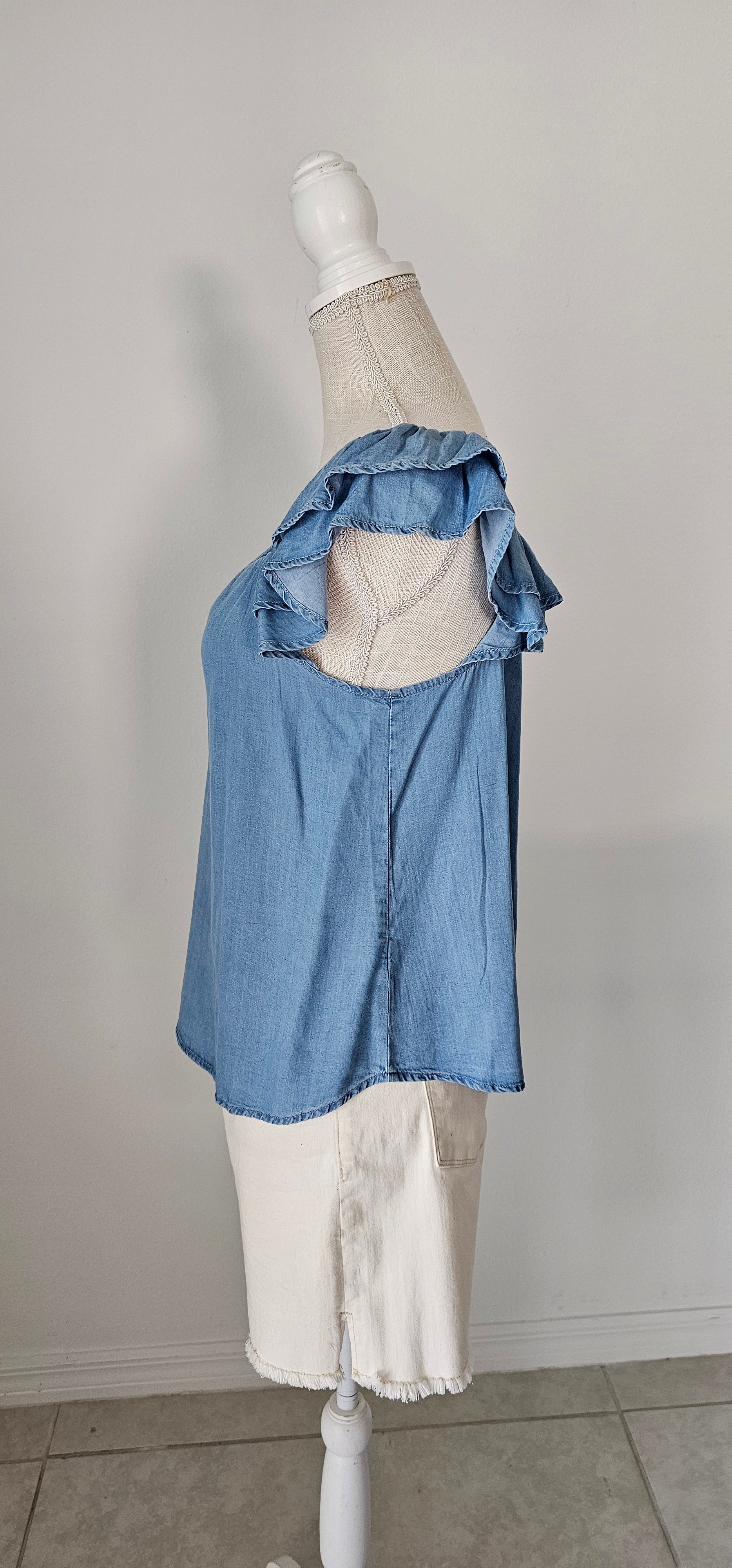 Look sharp and stylish this summer in our "Ashley Chambray Denim" top! Its flattering sweetheart neckline and sassy ruffle sleeves give you a unique, standout look. Plus, the square back neckline with elastic adds comfort! So why wait? Get out there and show off your denim 'look' with attitude. Sizes small through large.